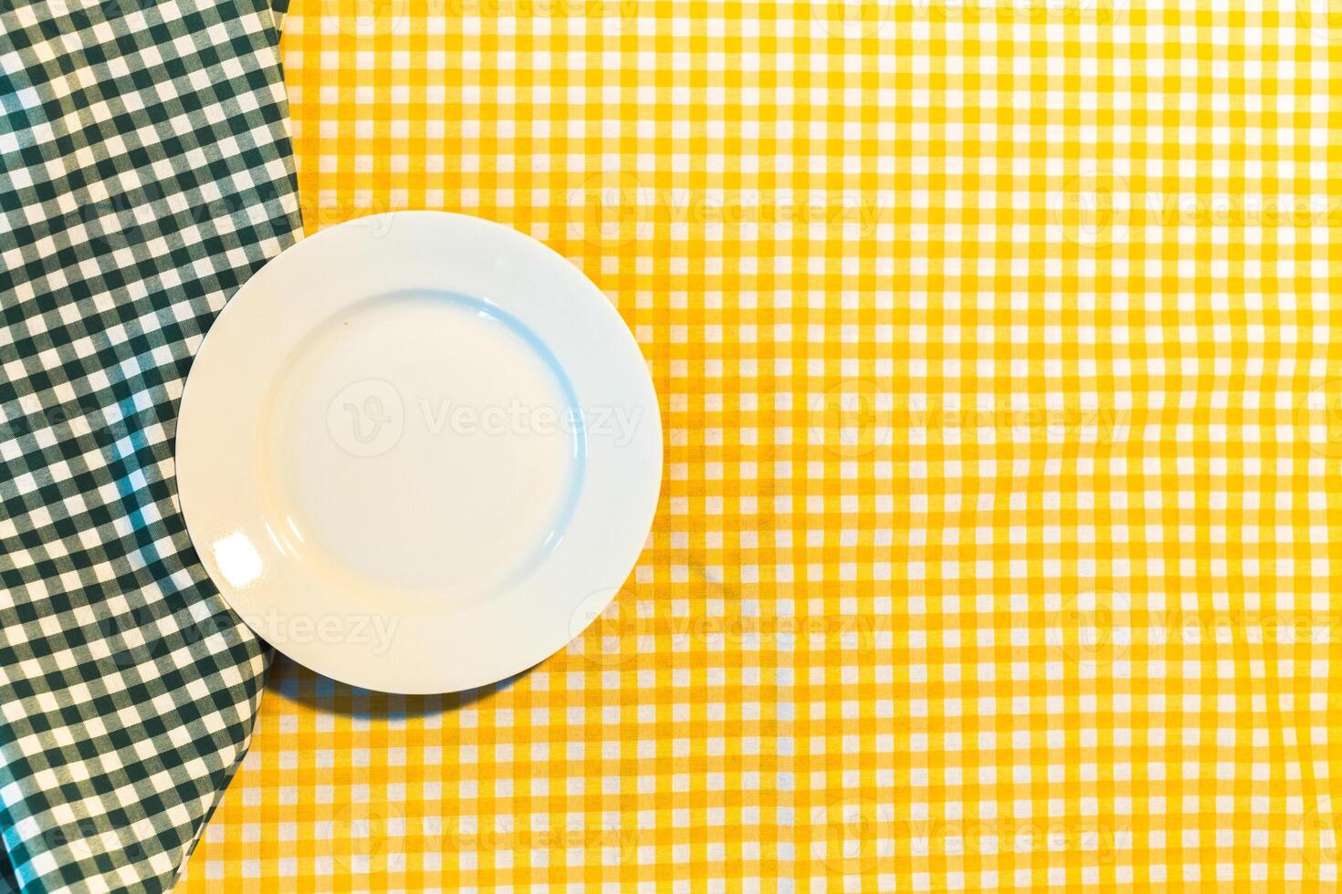 the plate on yellow checkered table cloth photo