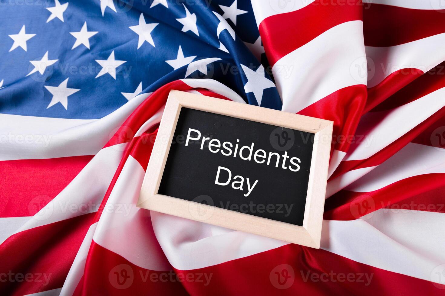 the text happy presidents day written in a chalkboard and a flag of the United States photo