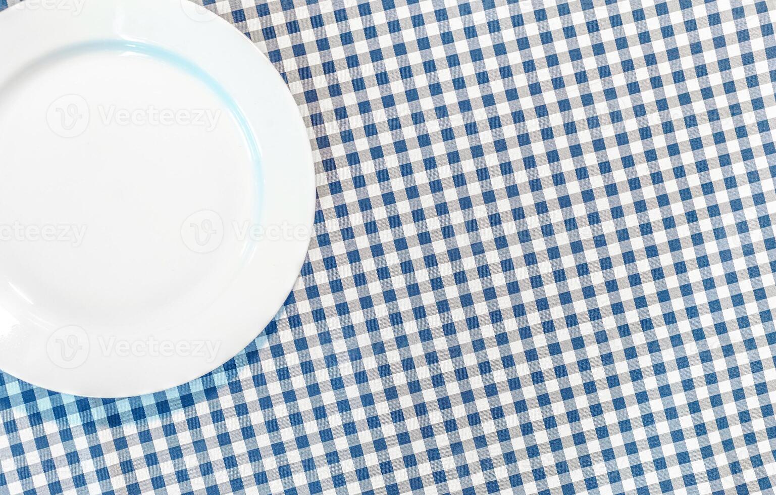 table with blue picnic cloth and plate photo