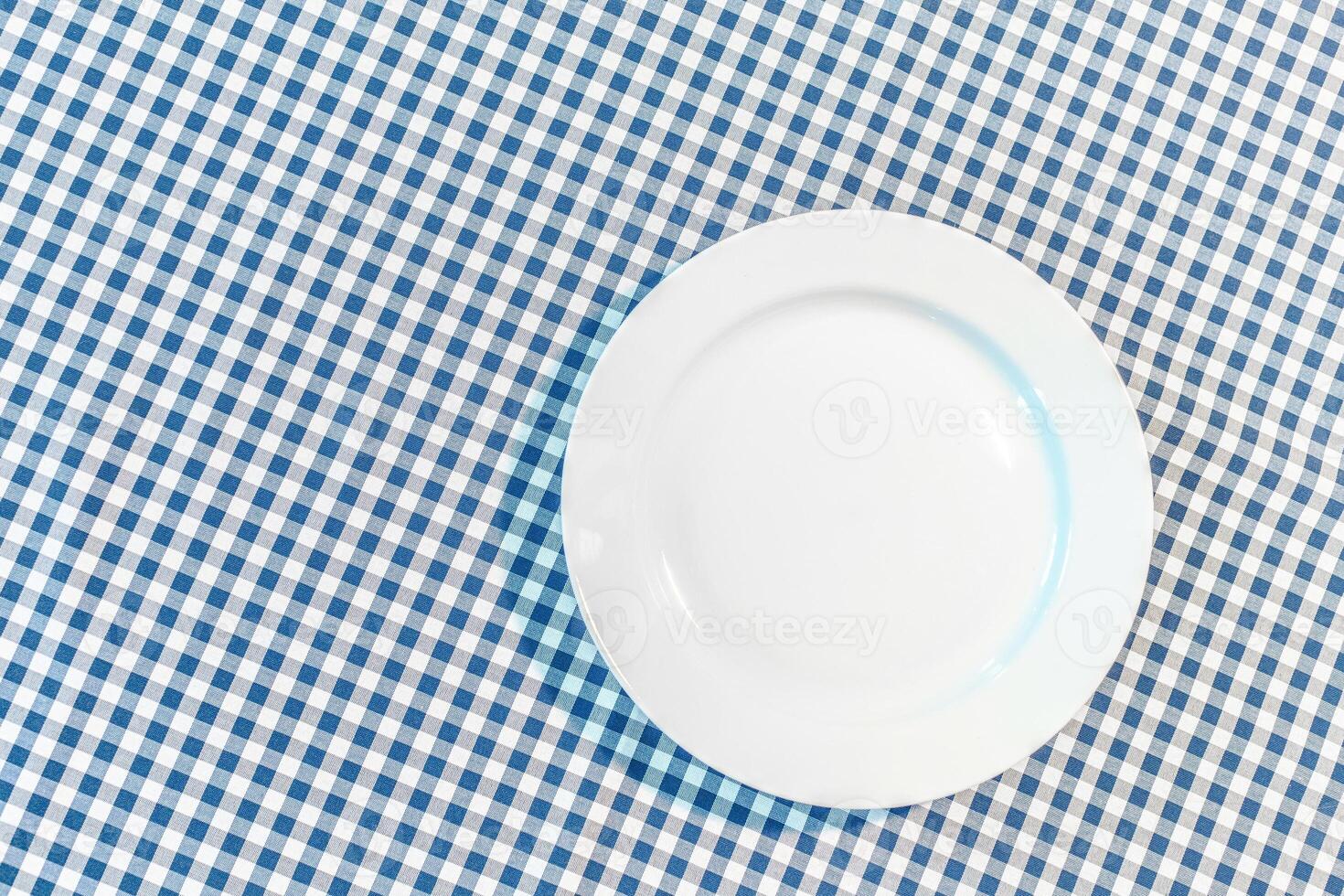 table with blue picnic cloth and plate photo