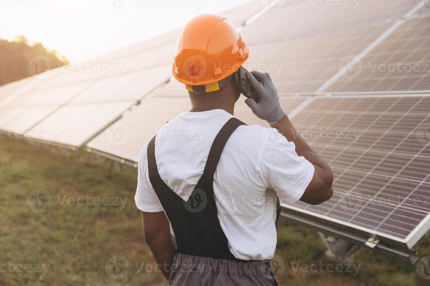 Engineer Inspecting Solar Panels While Making a Phone Call photo