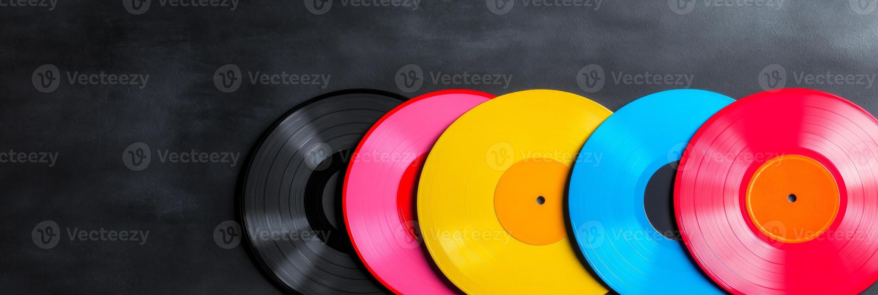 A colorful collection of retro vinyl records spread out on a dark surface designed for music enthusiasts photo