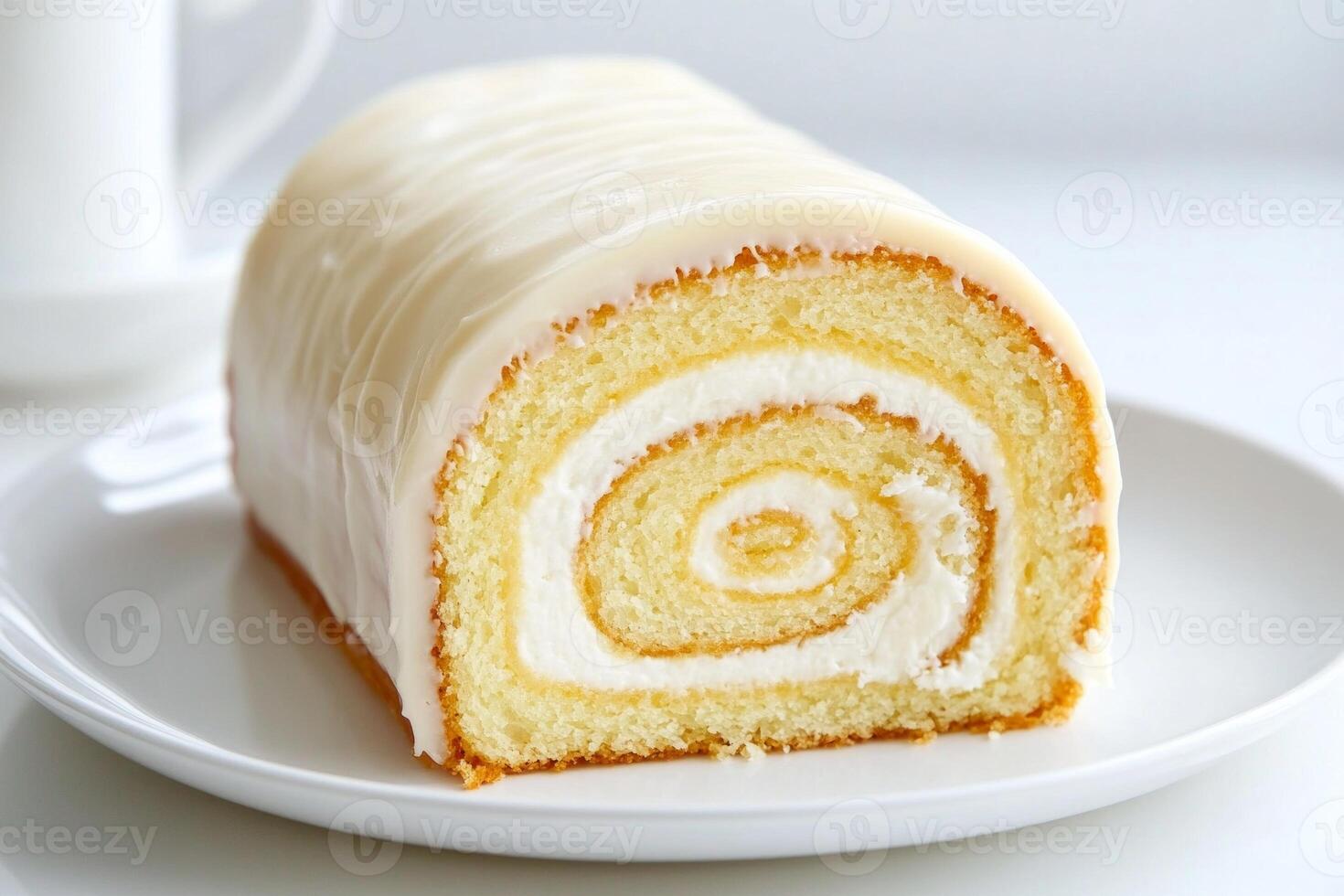 A delightful rolled sponge cake filled with cream cheese and showcasing a beautiful swirl pattern on a white plate photo