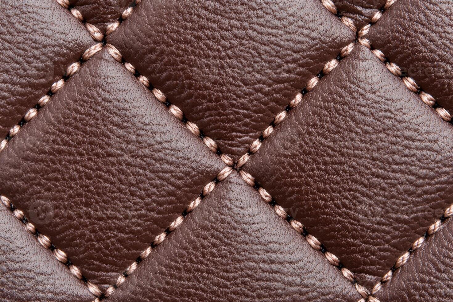 Luxurious quilted leather surface in rich brown featuring detailed stitching and a soft tactile finish photo