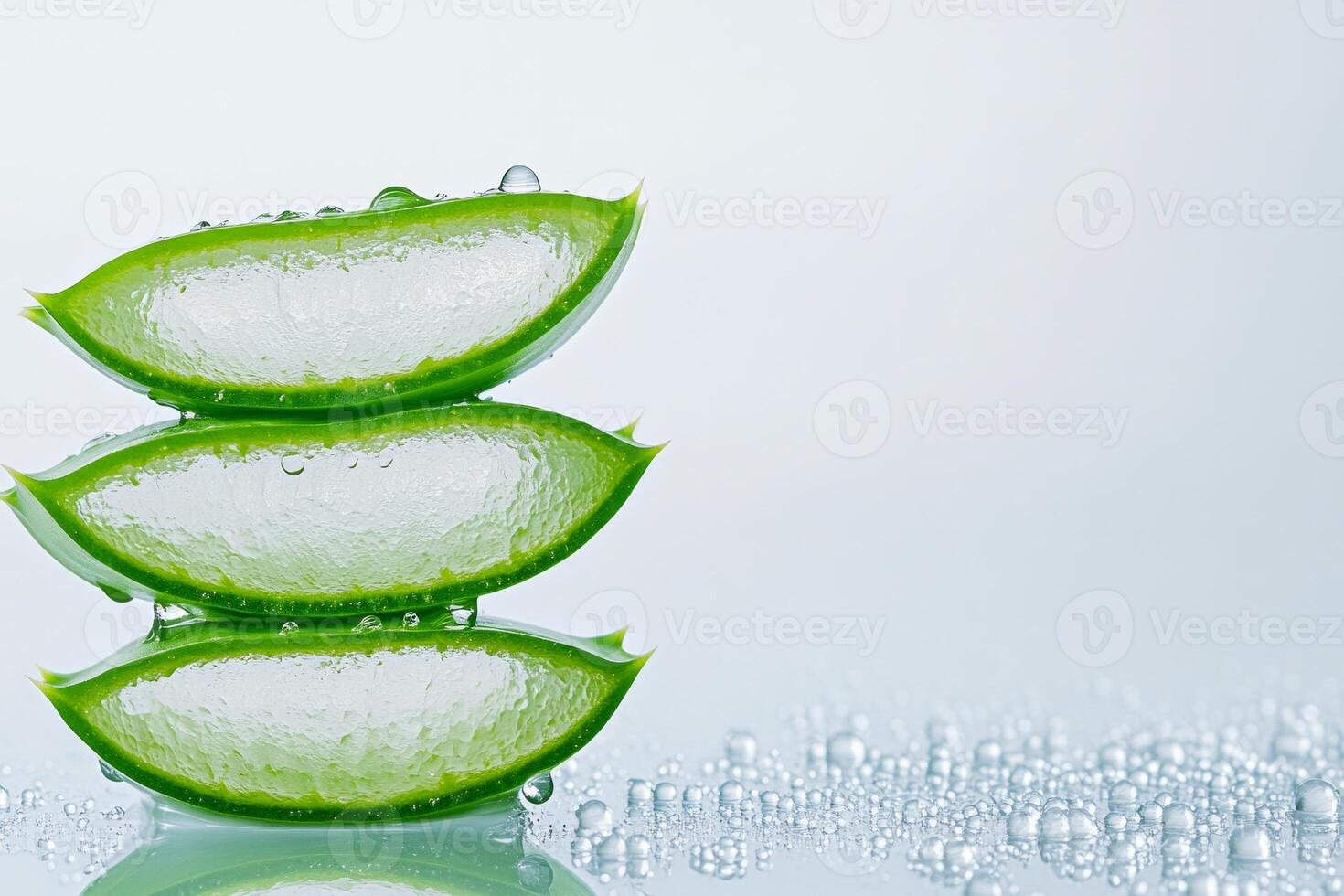 Fresh aloe vera leaves sliced open to showcase gel with hydration droplets on a white background photo