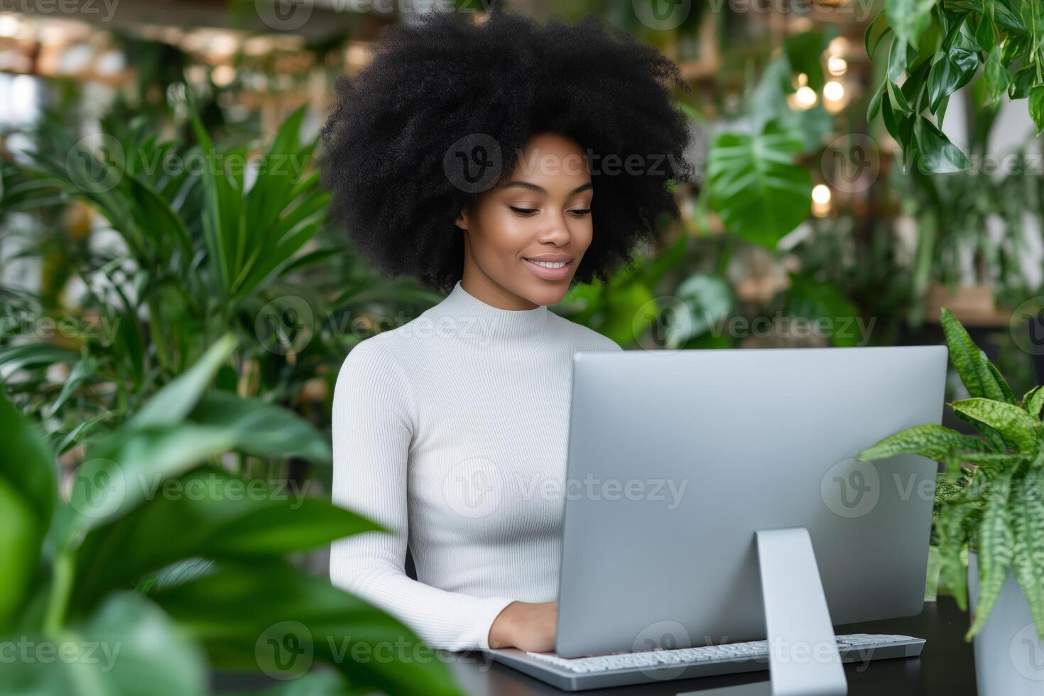 Young woman programming in a modern tech startup office filled with plants and soft lighting photo