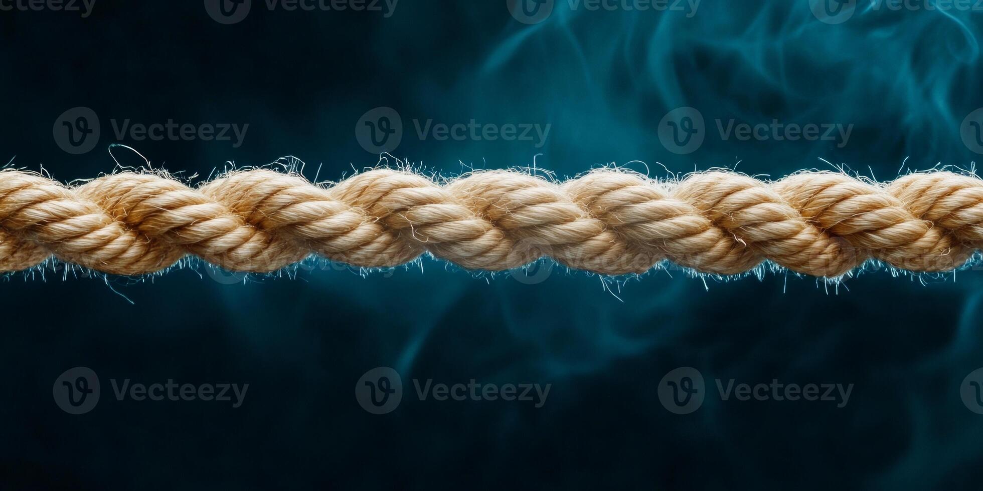 Frayed rope nearing breaking point with dramatic lighting against a dark background symbolizing tension and stress photo