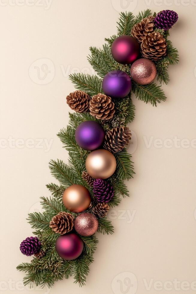 Festive border of green pine branches adorned with colorful ornaments and pine cones on a warm beige background photo