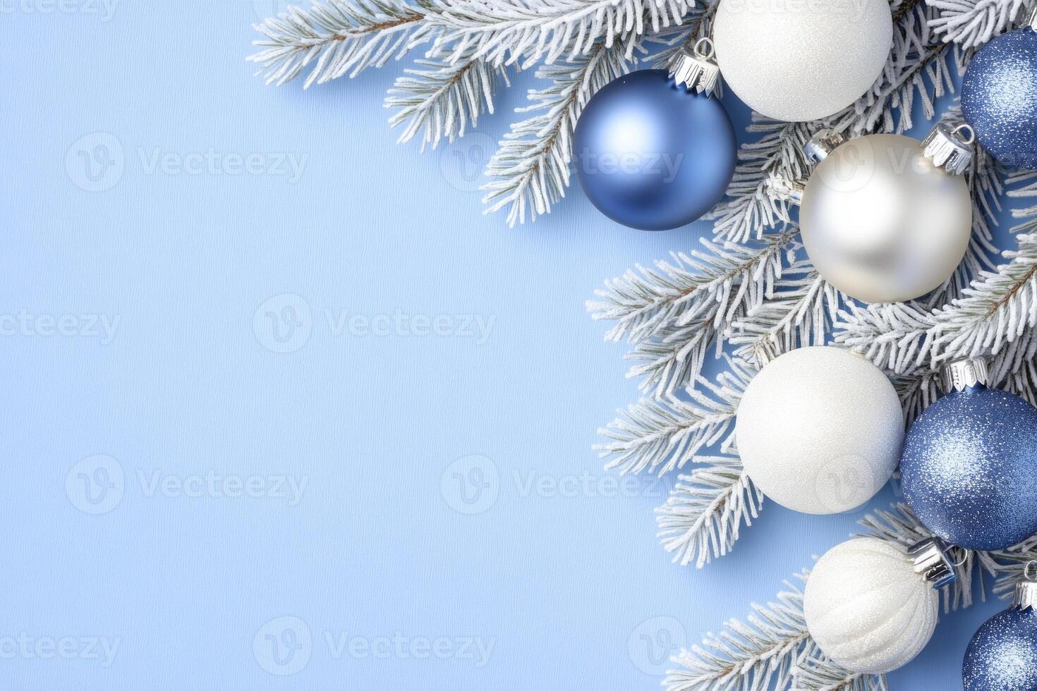 Delicate Christmas frame with frosty pine branches and silver blue ornaments on a soft blue background photo