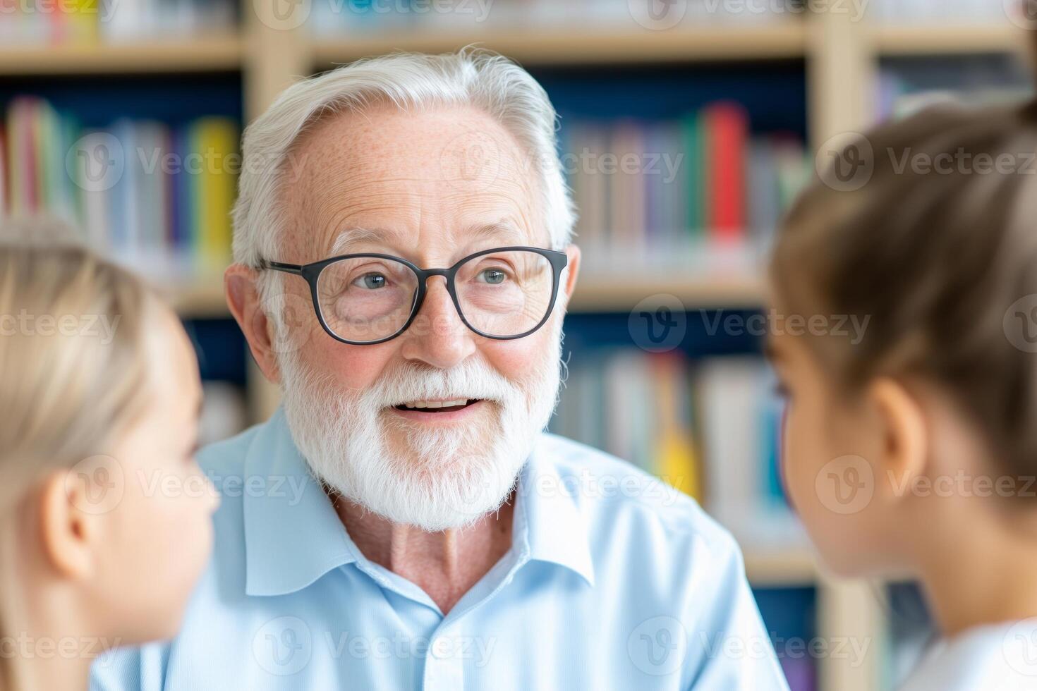 Elderly man with glasses explains concepts to young students in a cozy library setting surrounded by books photo