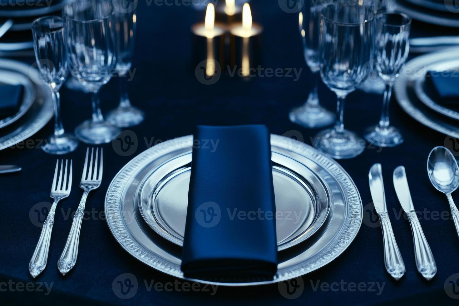 Elegant luxury dining table with silver cutlery and dark blue accents for an intimate evening gathering photo
