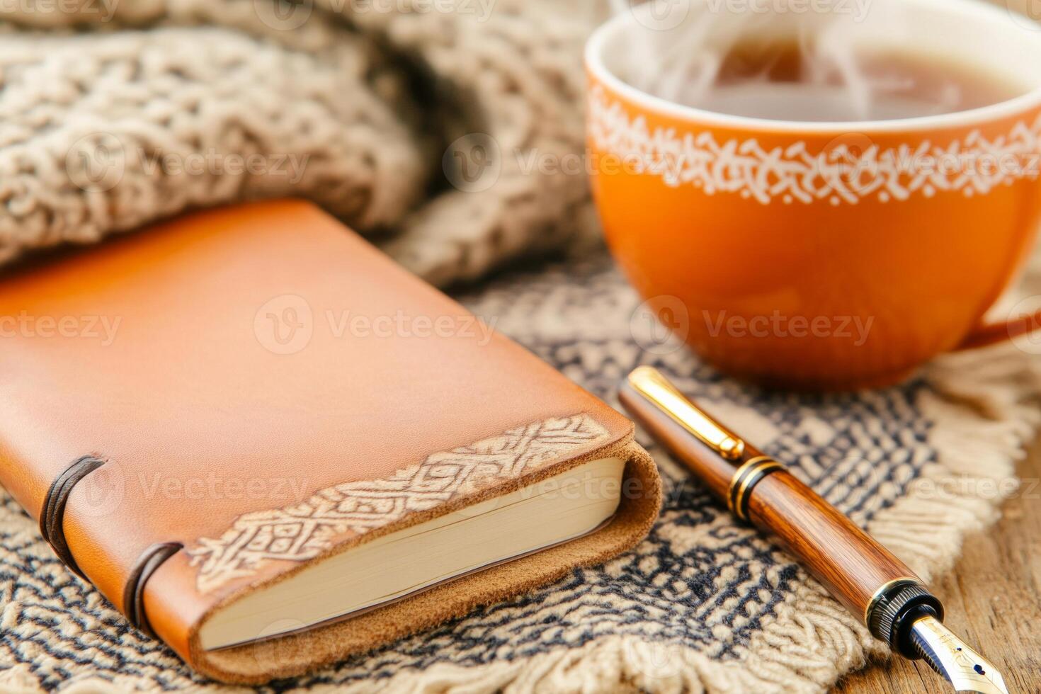 A cozy wooden desk setup featuring a leather journal, fountain pen, and steaming cup of herbal tea photo