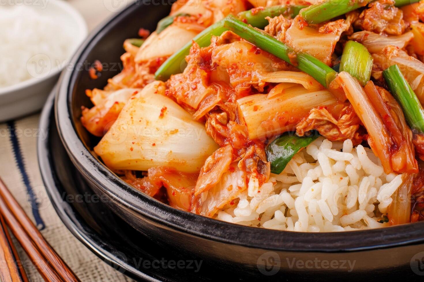 Fresh kimchi served with rice and side dishes in a traditional Korean dining setup with chopsticks photo