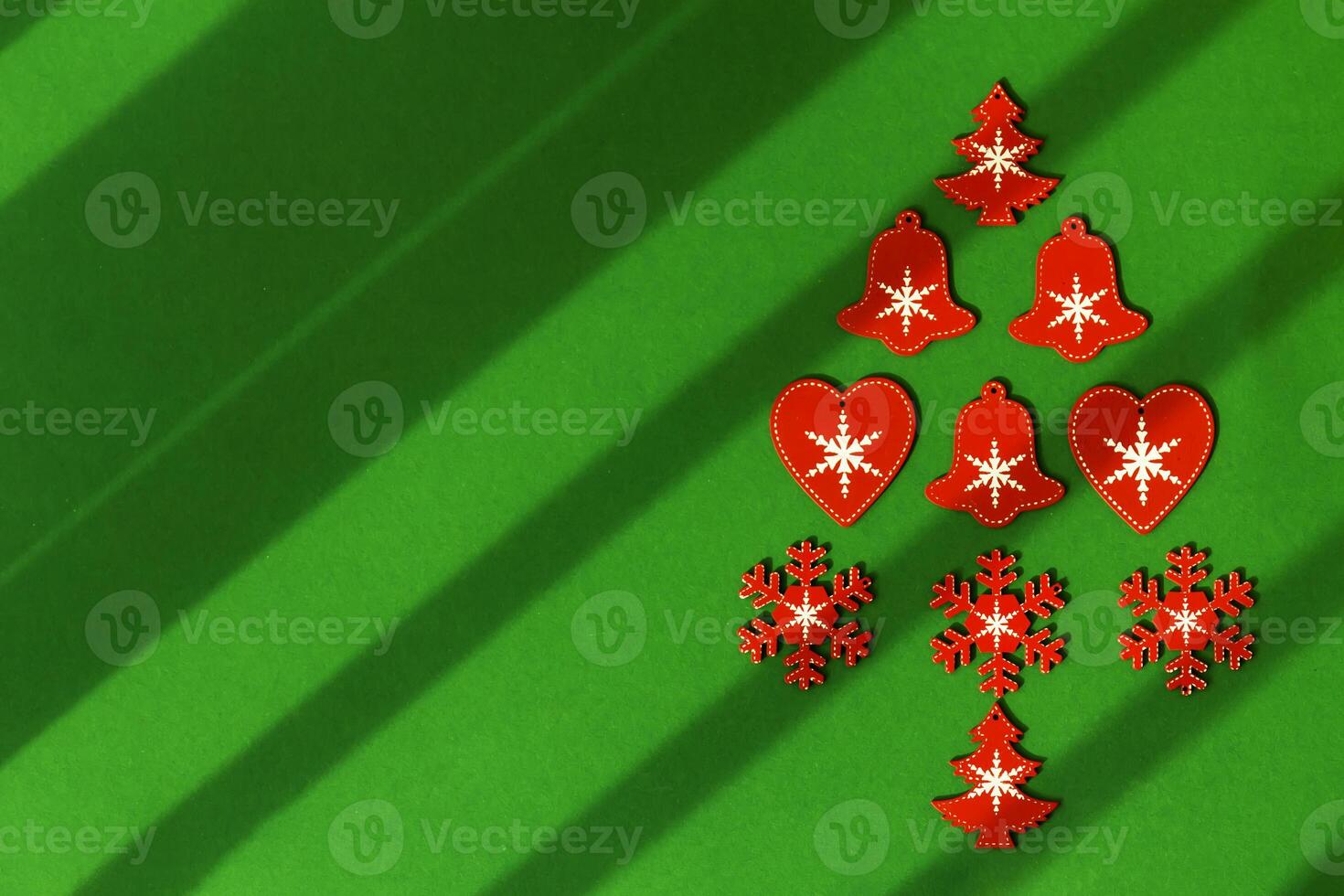 Red Christmas tree made of wooden Christmas tree toys on a green background with diagonal lines photo