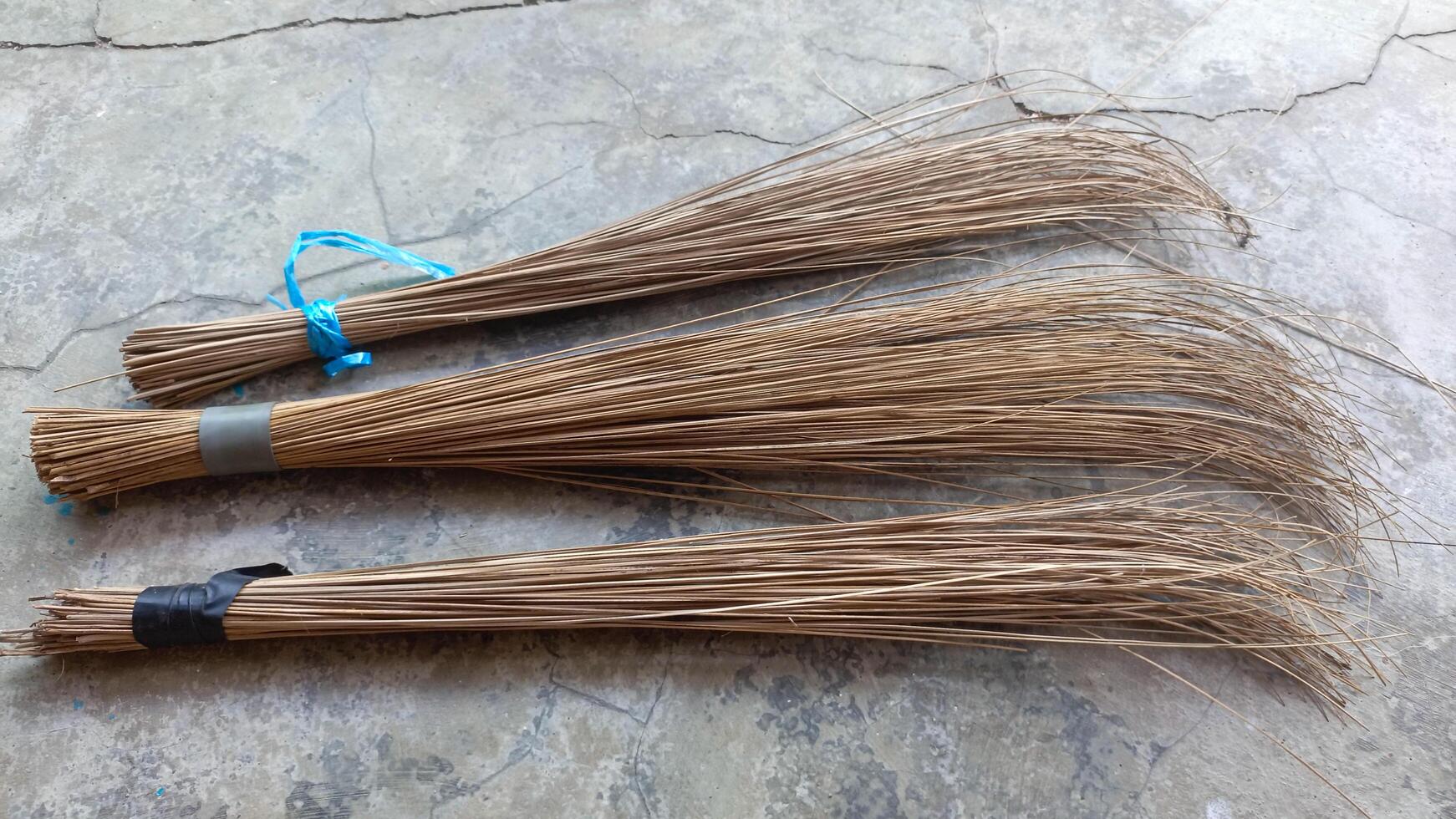 Sapu lidi or broom stick. Cleaning tool for sweeping. Traditional equipment. Placed on the floor. photo