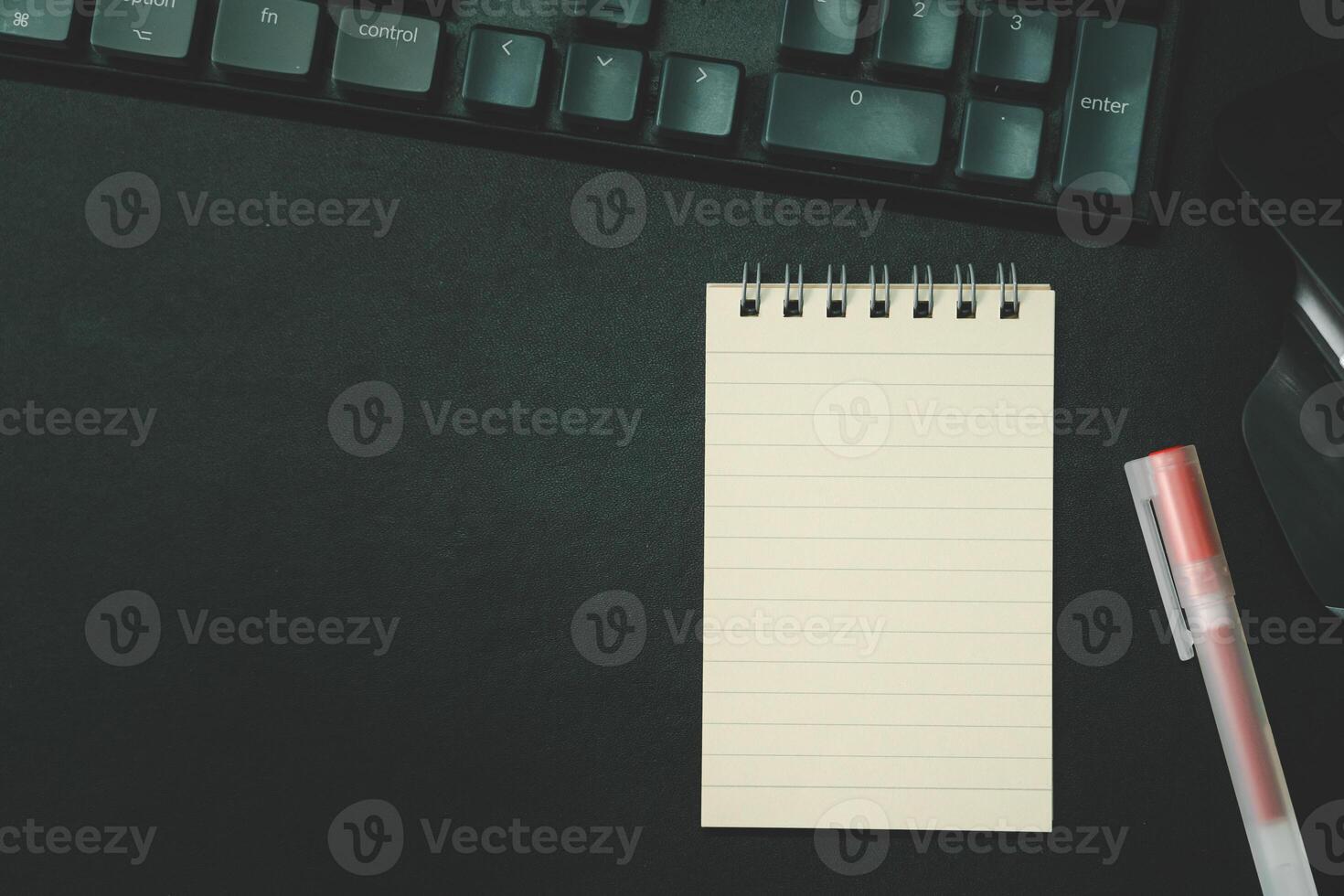 Top view of notebook. Blank paper notepad on office desk table with keyboard and other supplies. Blank notebook page for input the text. copy space, flat lay. photo