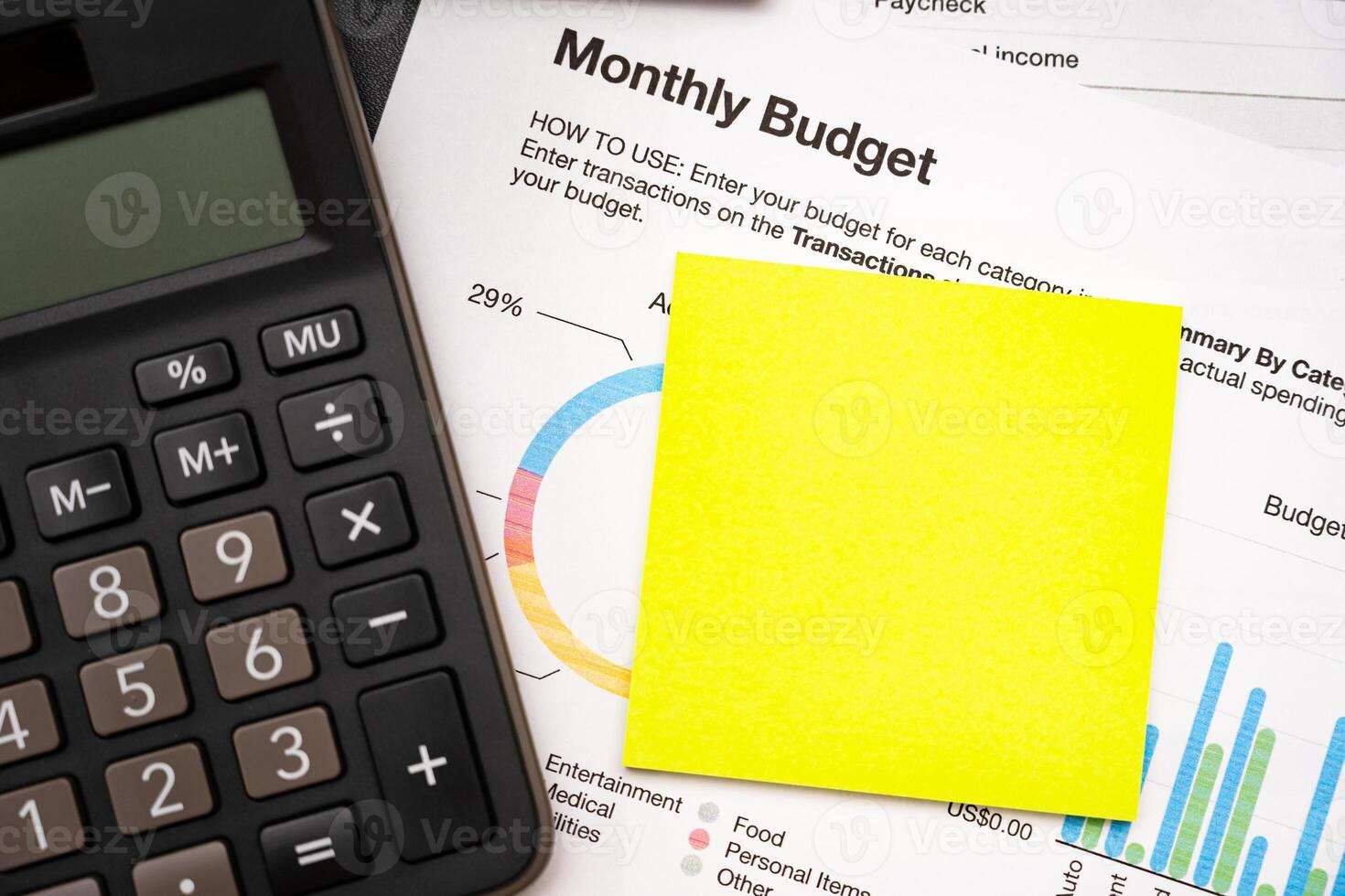 Blank Sticky note with calculator on desk with monthly budget graph. Financial data analyzing. Working on desk with using calculator, finance accounting. Copy space. photo