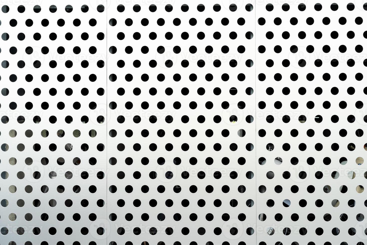 Metal background with holes. Steel plate with many circular holes drilled. Steel backdrop with holes. Stainless material with dots. photo