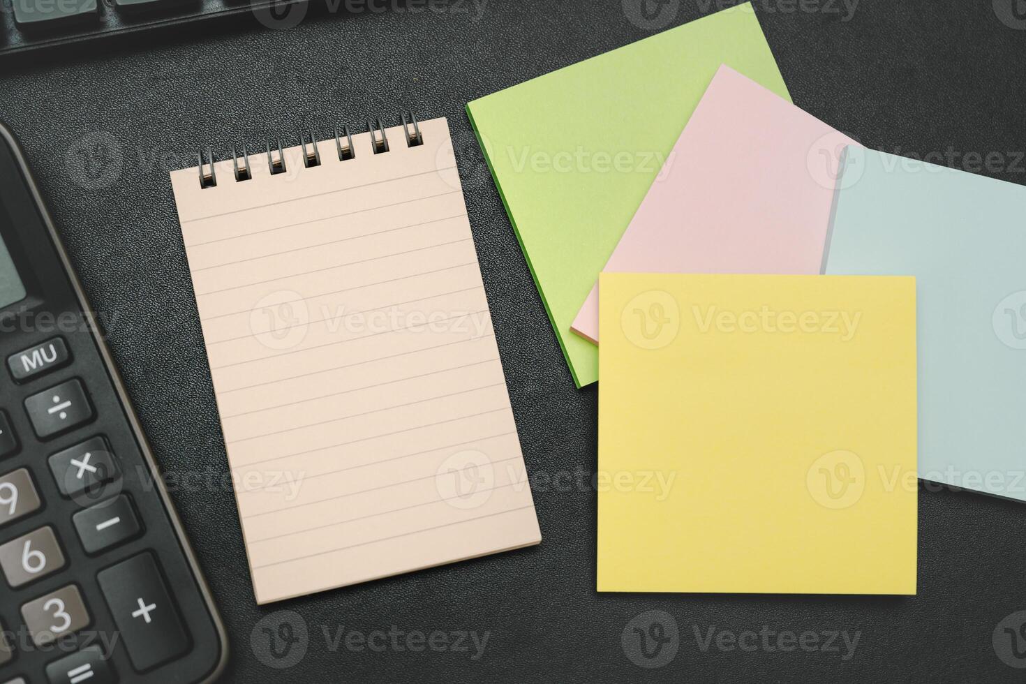 Top view of notebook. Blank paper notepad on office desk table with keyboard and other supplies. Blank notebook page for input the text. copy space, flat lay. photo