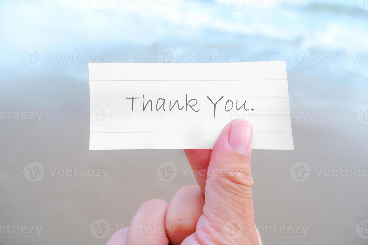 Thank You message in a hand at the beach photo