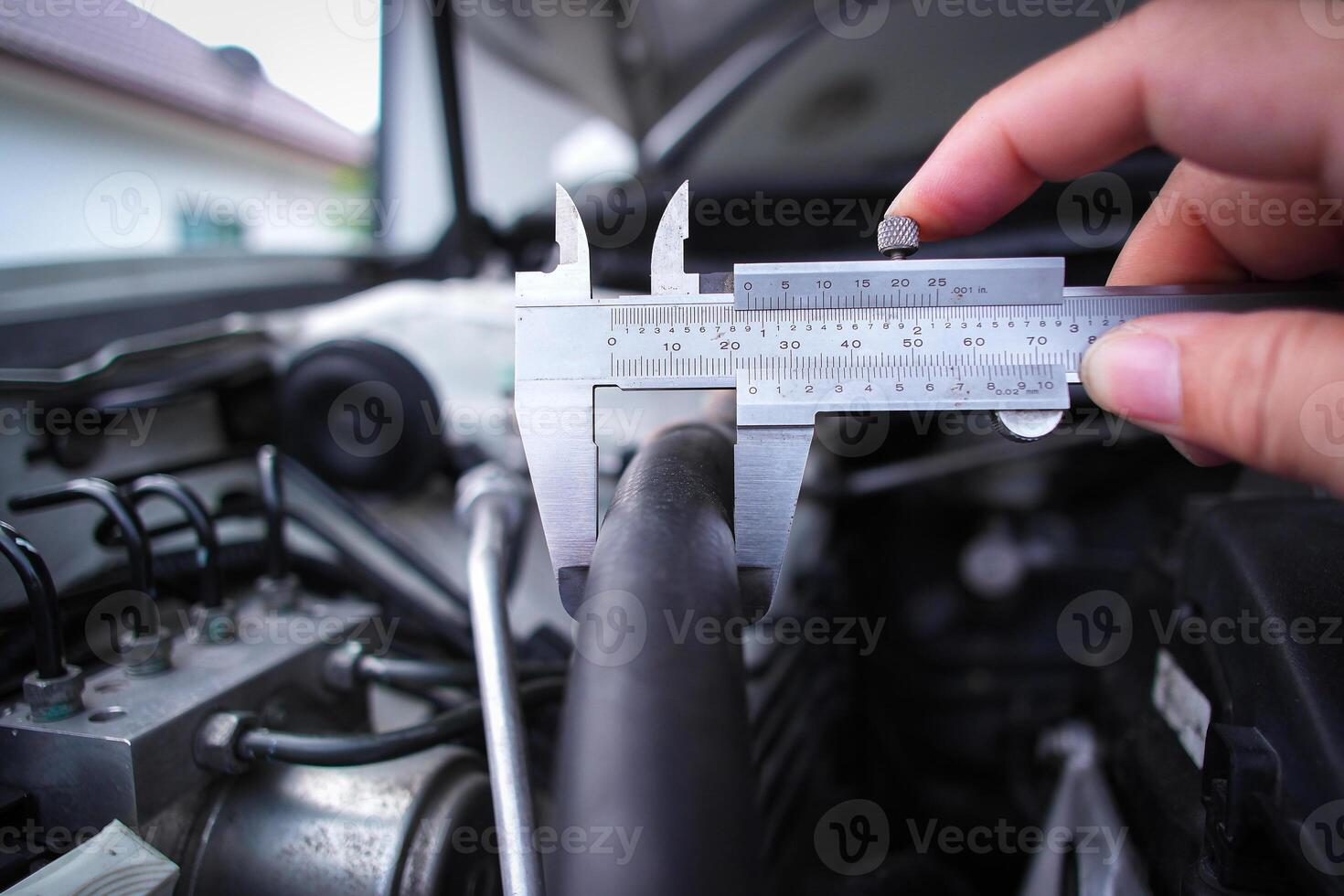 Close up of vernier caliper measuring rubber tube of engine component , Mechanic tools concept photo