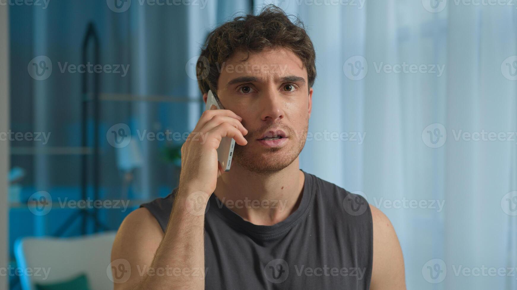 Caucasian man athlete talking mobile phone smartphone call sport guy male sportsman technology telephone anger annoyed frowning unhappy dissatisfied displeased home training problem communicate gadget photo
