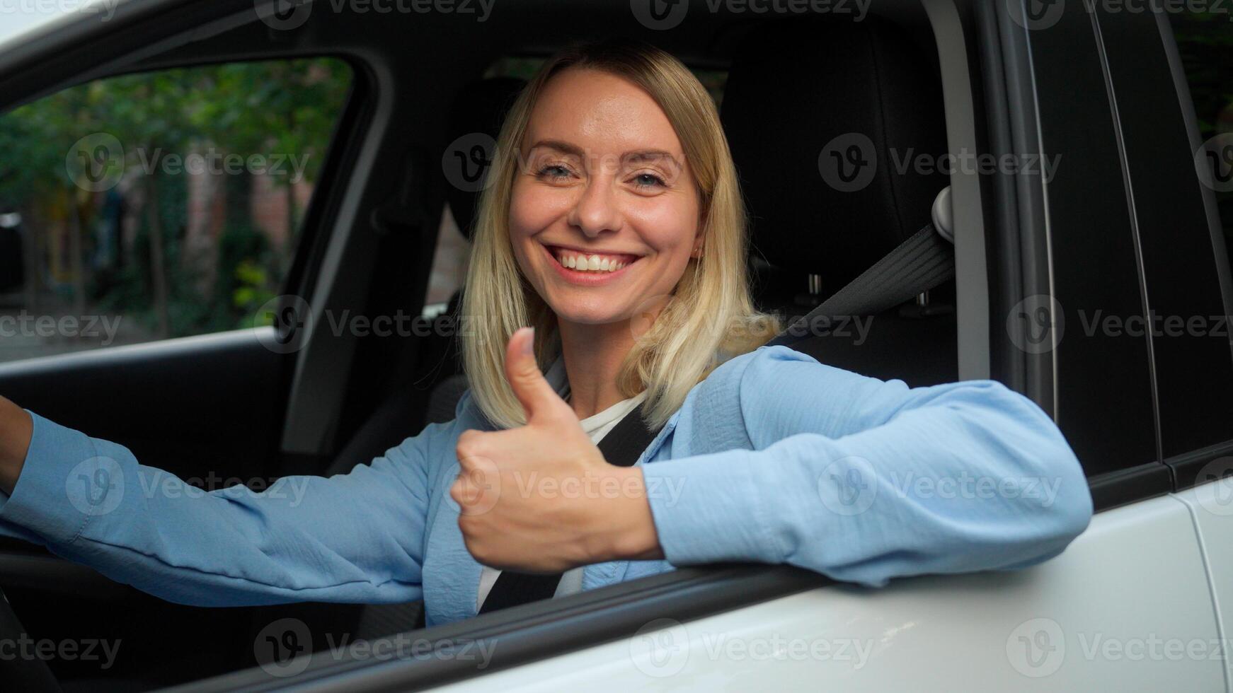 Happy Caucasian businesswoman female woman in car automobile owner fasting seat belt safety girl driver smile demonstrating thumb up in city ride driving test drive auto renting transport buy vehicle photo