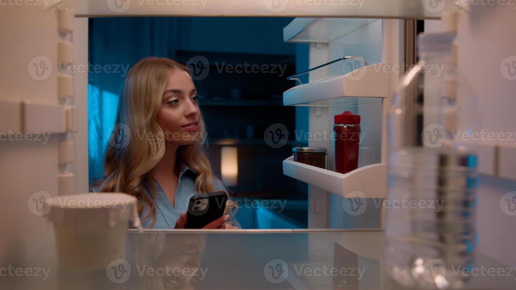 Point of view POV inside refrigerator Caucasian girl hungry woman open fridge at home kitchen look at empty shelves order food products delivery with mobile phone app online service web store shopping photo