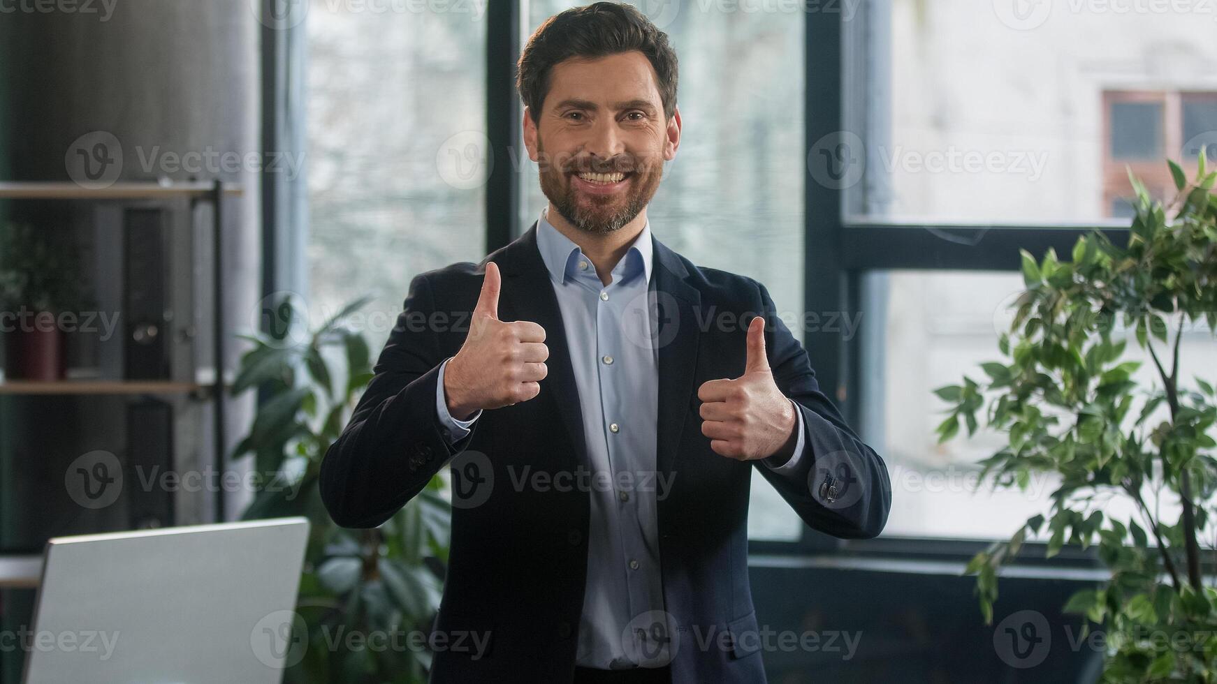 Focused adult caucasian man recruiting agent standing in office making notes writing checklist businessman conducts inspection write strategic plan showing thumb up gesture approval best choice sign photo