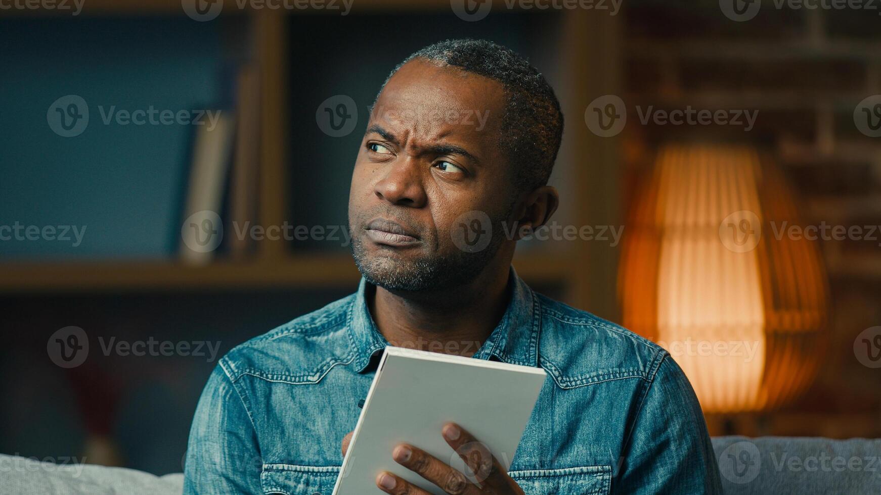 Pensive adult african american man indoors thinking deep in thoughts create strategy thoughtful businessman making notes in notebook planning searching for solution writing down idea write memories photo