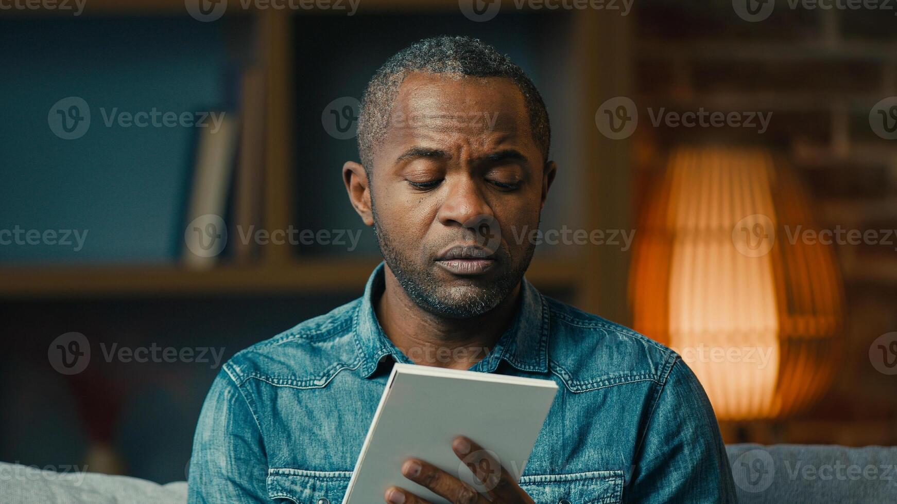 Pensive adult african american man indoors thinking deep in thoughts create strategy thoughtful businessman making notes in notebook planning searching for solution writing down idea write memories photo