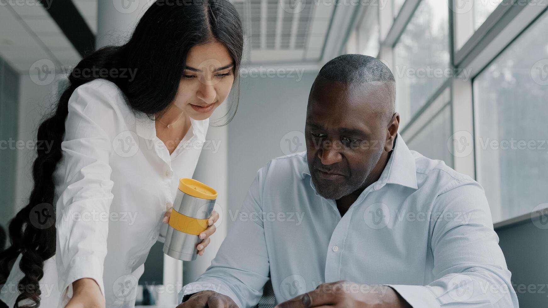 Two colleagues business partners office co-workers analyze paperwork check information. Arabian woman check documentation papers report help african older man with marketing data corporate documents photo