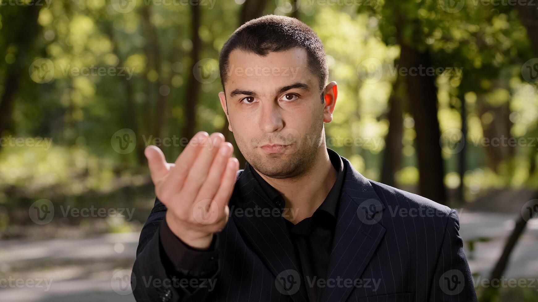 Caucasian businessman with strong serious eyesight adult confident man wear formal black suit pointing finger at camera hey you come here inviting hand gesture welcome symbol calling to show something photo