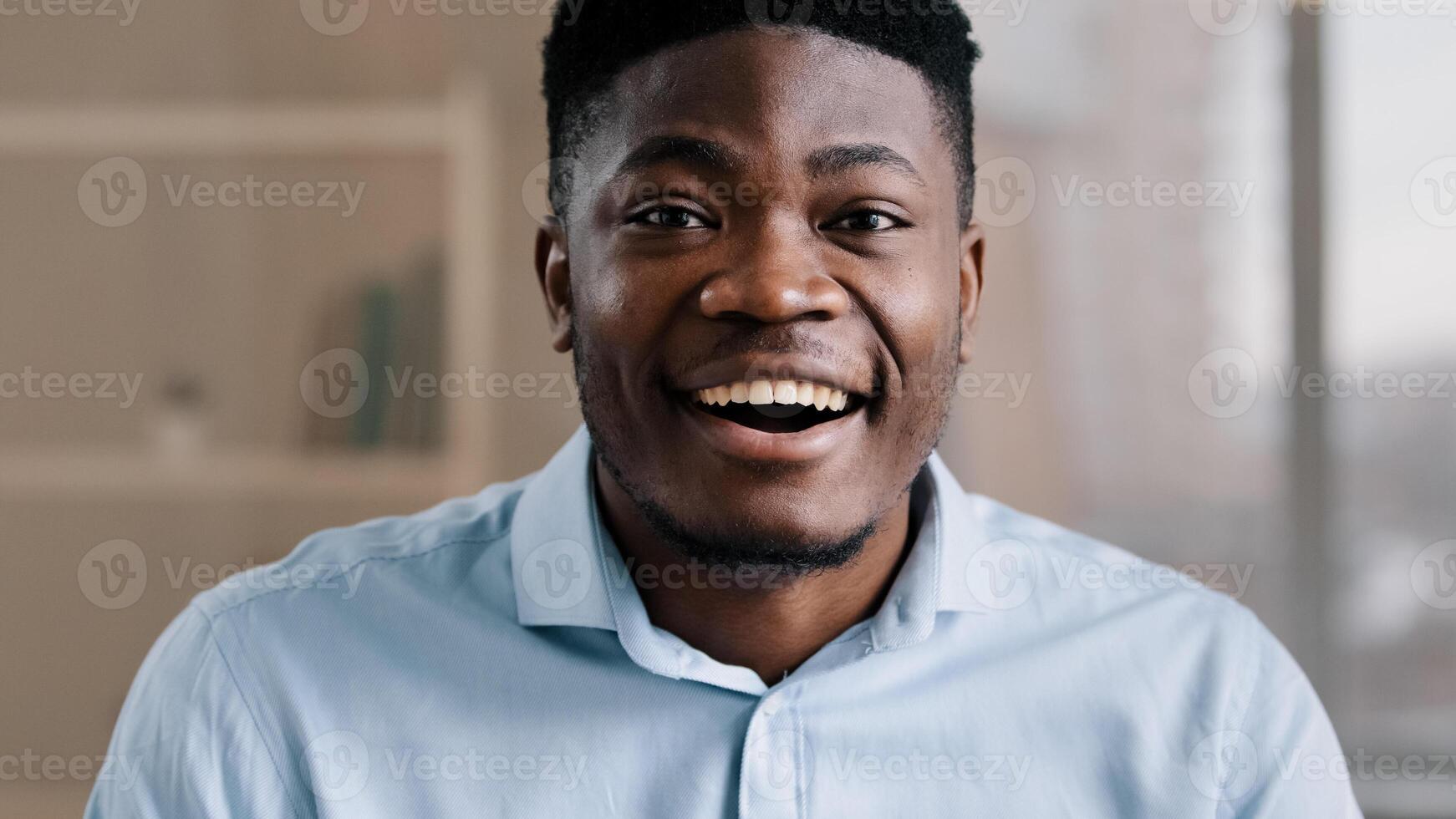 Pleasantly surprised african american man wears blue shirt makes big eyes feels shock open mouth in astonishment wow reaction joyful happy amazed male face expression looks at camera hears good news photo