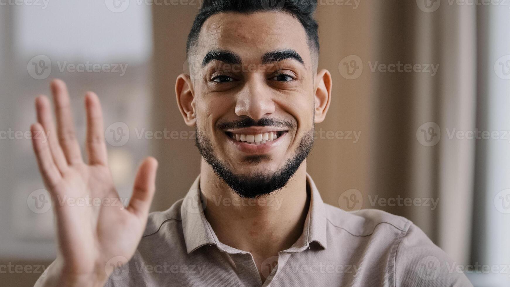 Hispanic handsome business man millennial wave hand greet look at camera arab friendly guy record lifestyle blog provide distance tutorial educational course use internet online web application photo