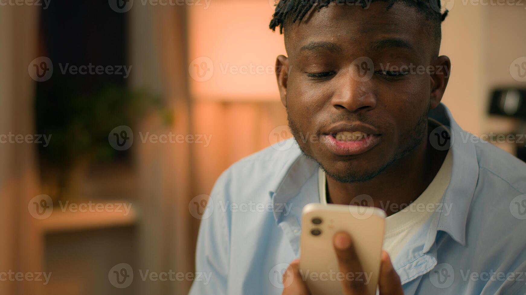 Angry mad furious aggressive stressed man African American male guy at evening home argue conflict talking mobile phone call problem bad relationship trouble stress shouting screaming arguing quarrel photo