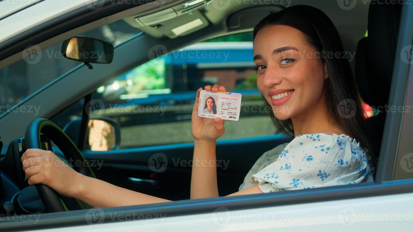 Happy glad positive Caucasian smiling woman female driver car owner auto buyer client sitting inside automobile looking at camera showing digital driving license passed exam drive courses rent vehicle photo