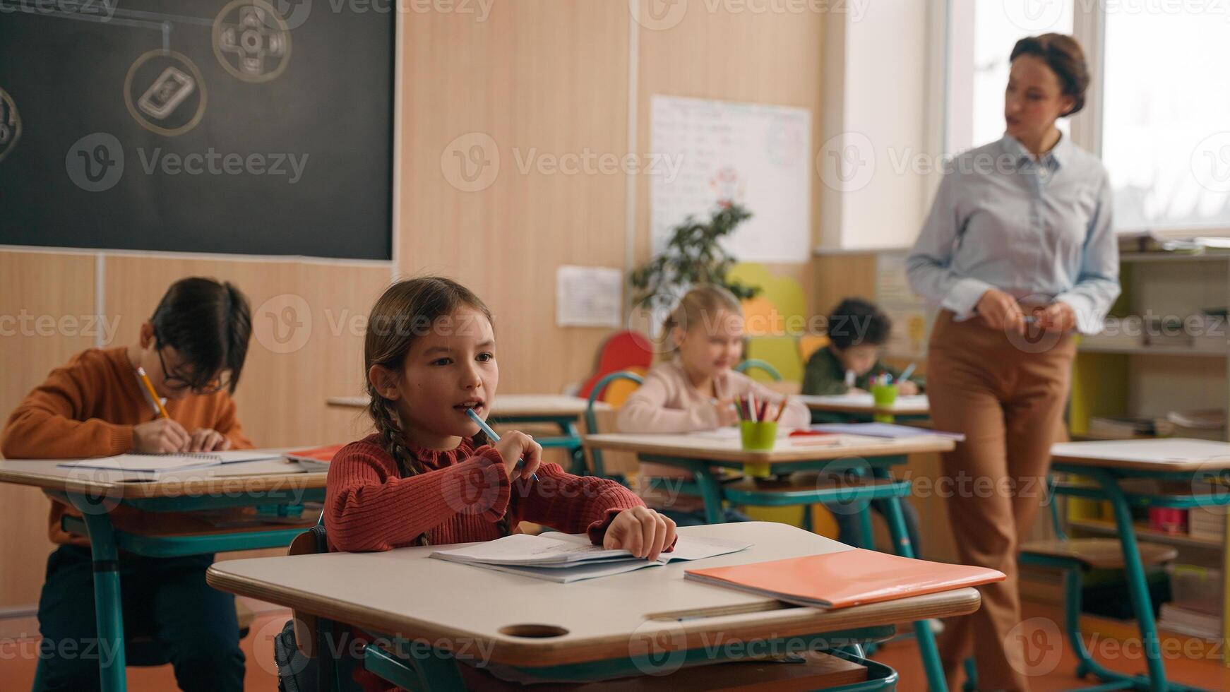 School class lesson children studying learning in classroom woman teacher female tutor walking teaching little boy child kid rise hand ask help question answer study learn write talking education photo