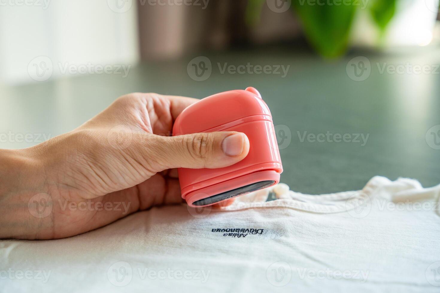 Close-up view of woman's hands with a stamp with a name for signing children's things. Identification of personal clothing. High quality photo