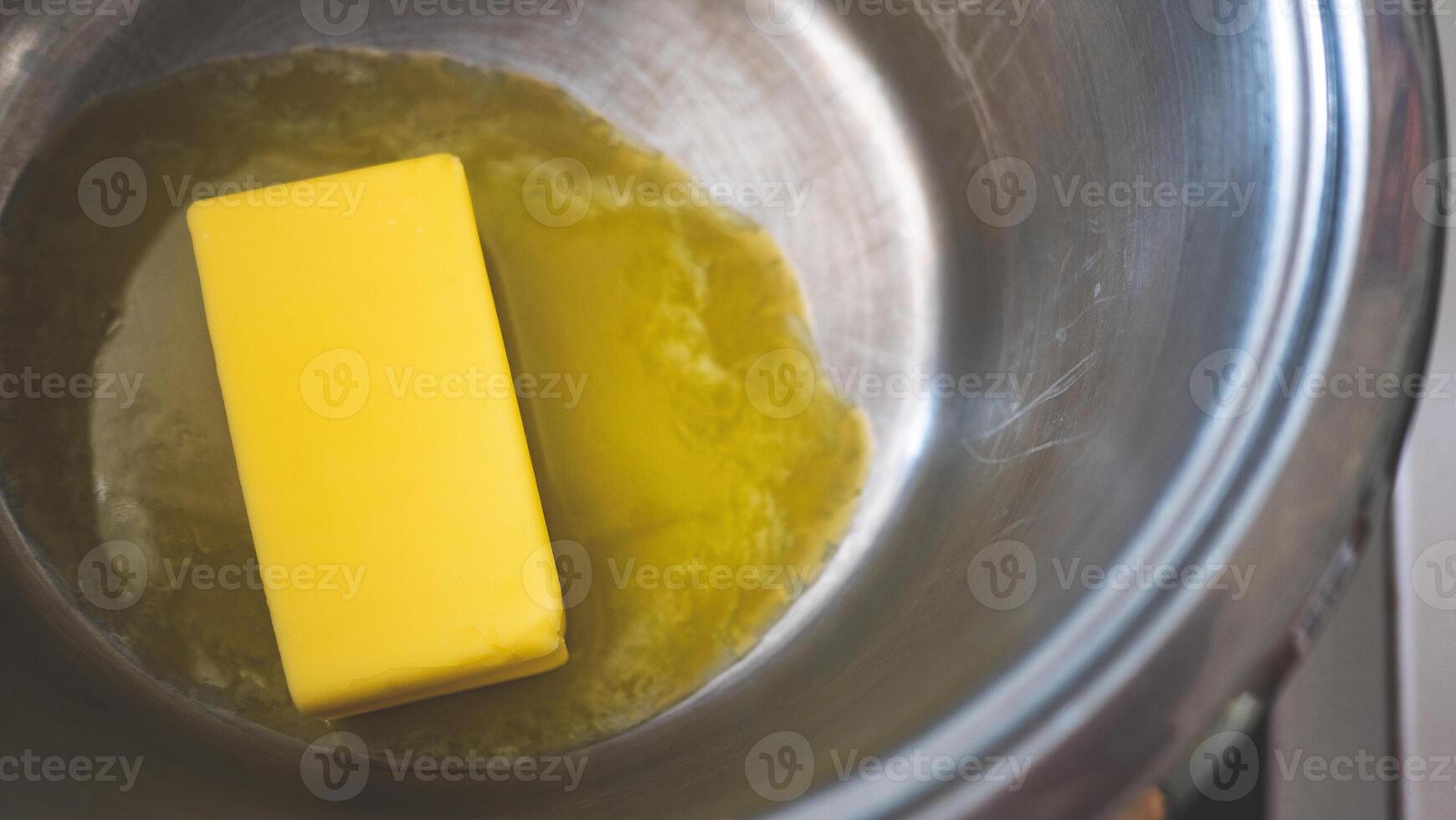 A stick of butter melting in a pot cooking close up photo