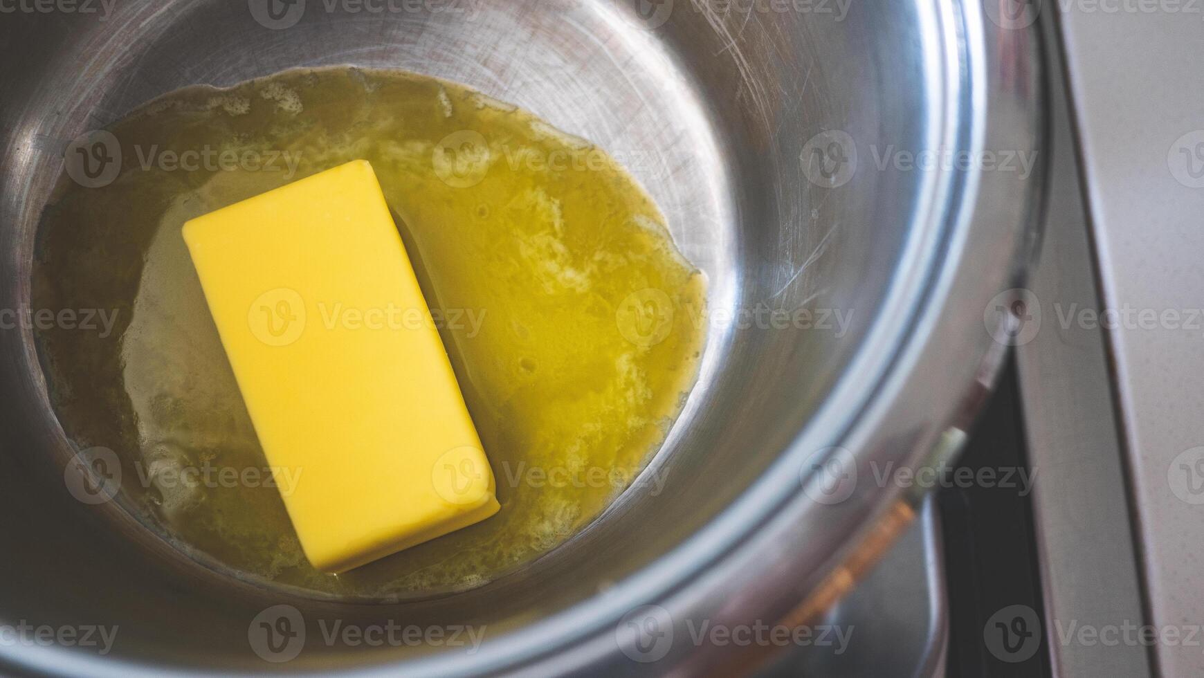 A stick of butter melting in a pot cooking close up photo