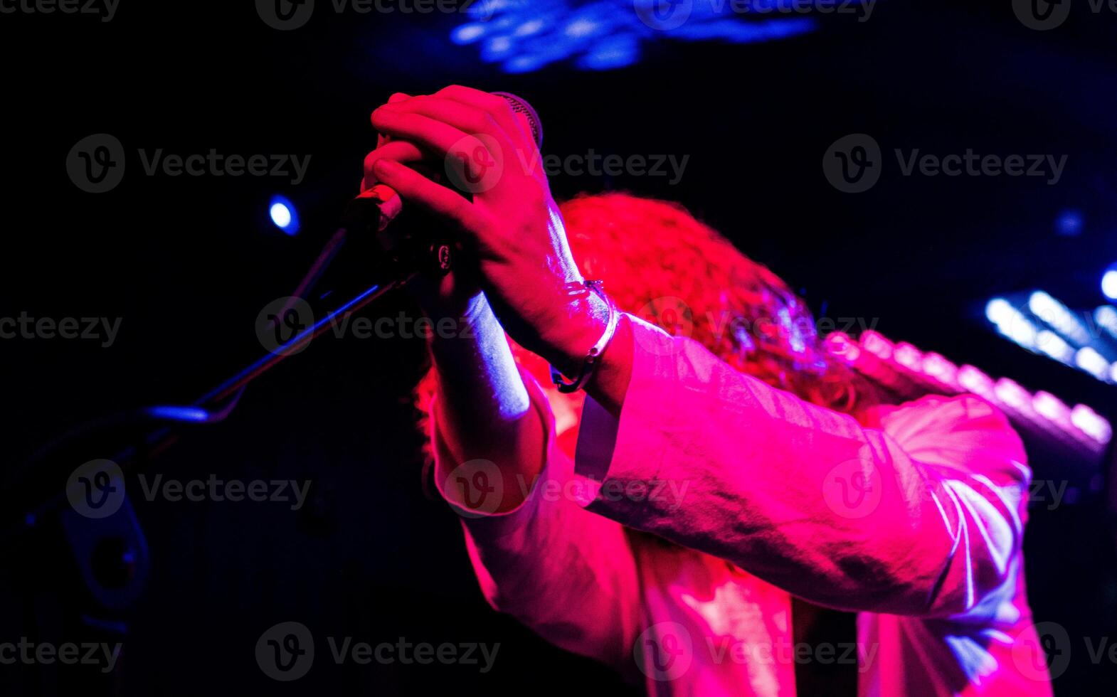 Live music performance singer holding a microphone hands close up photo