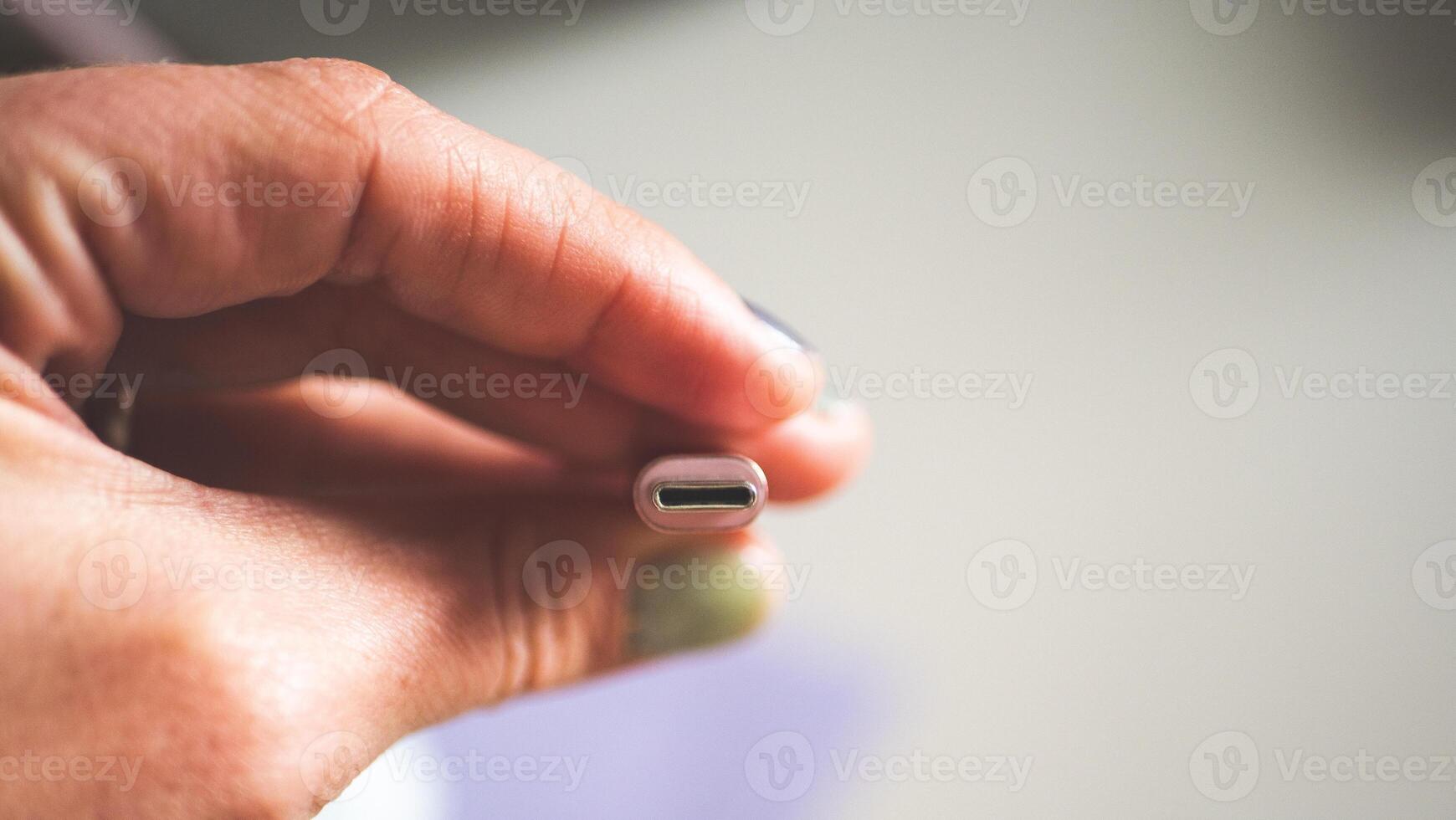 A hand holding usb plug c type close up minimalist technology photo