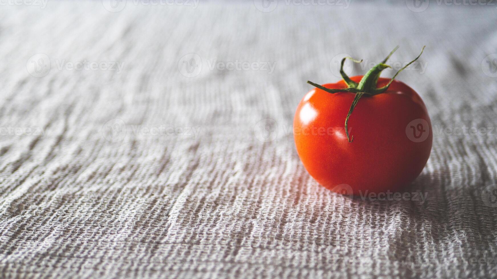 A tomato on fabric light background red simplicity minimalist photo