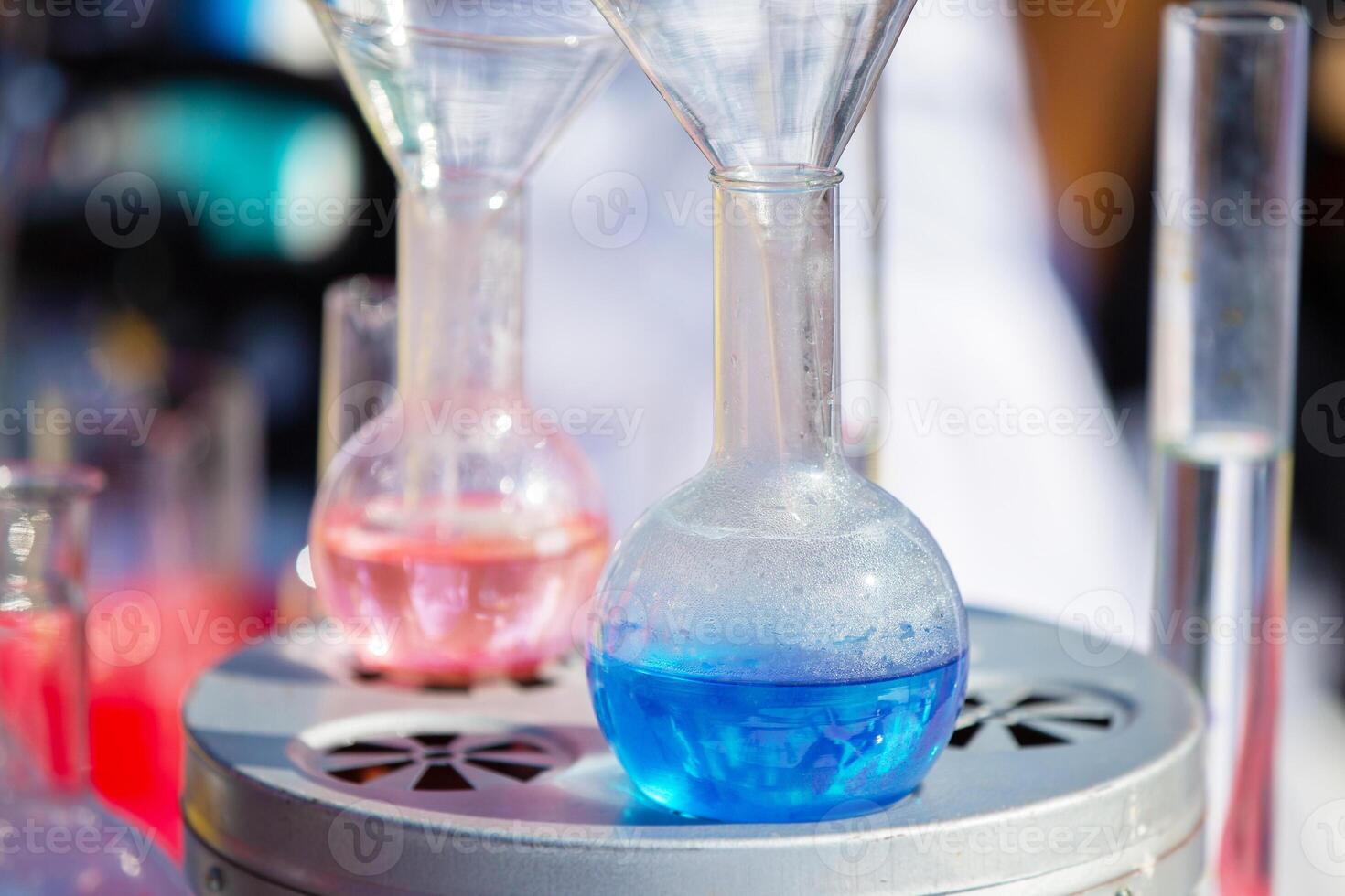 Transparent laboratory flask with blue liquid or chemical solution. photo