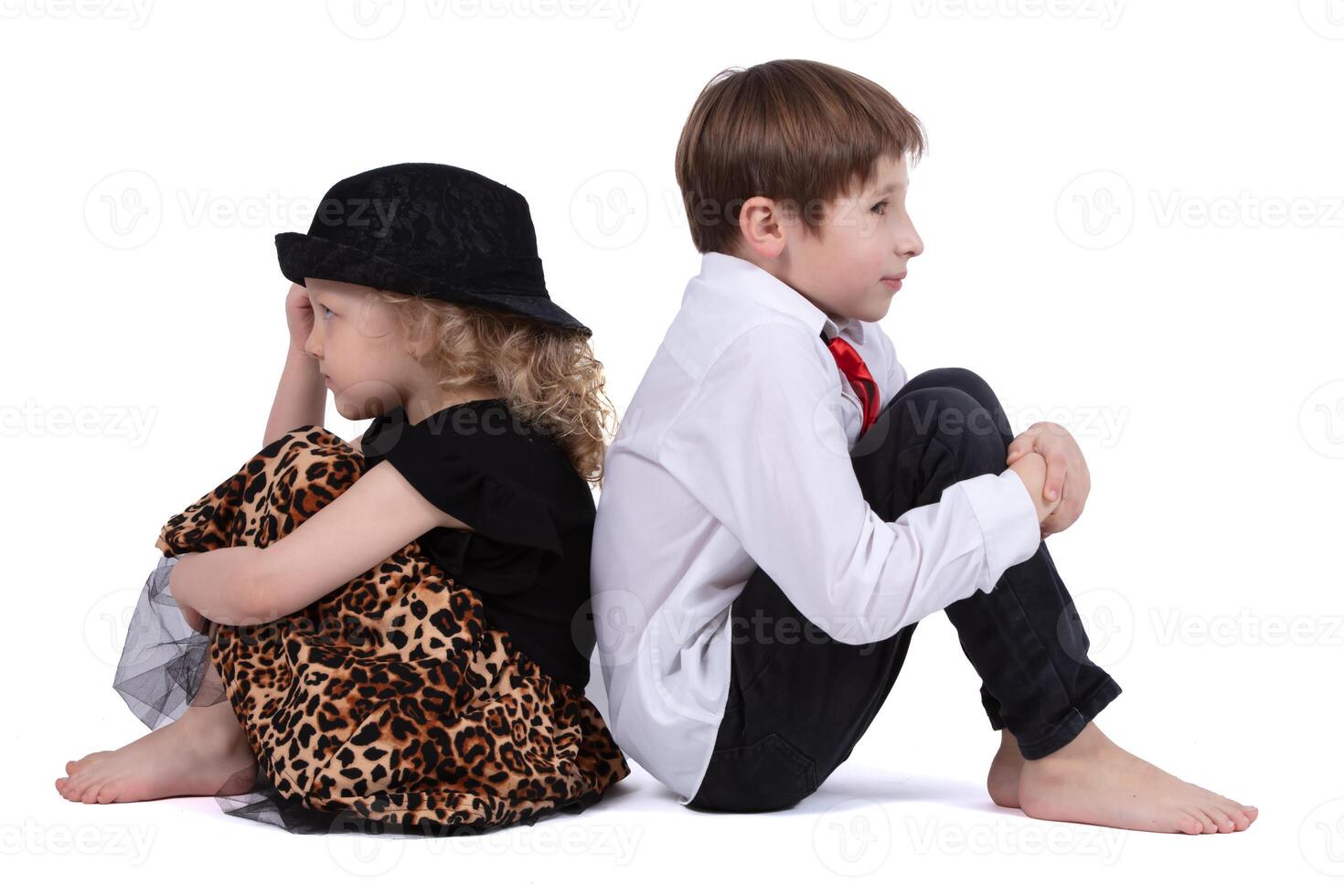 A quarreling little boy and girl are sitting with their backs to each other. Children's grievances photo