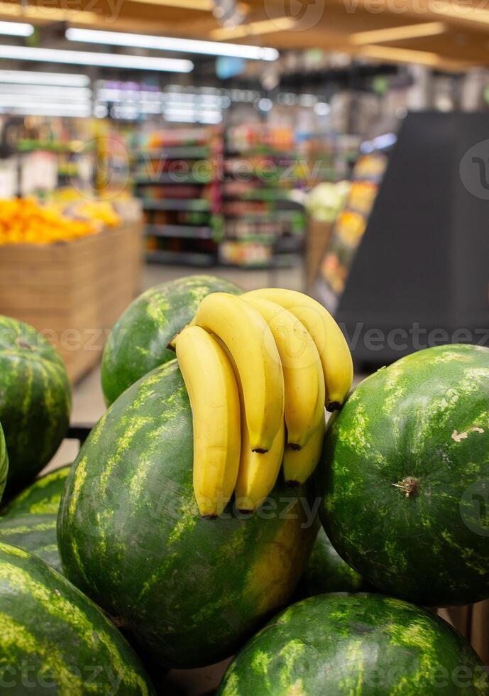 Fruits and berries bananas and watermelons on the background of a blurred store. photo