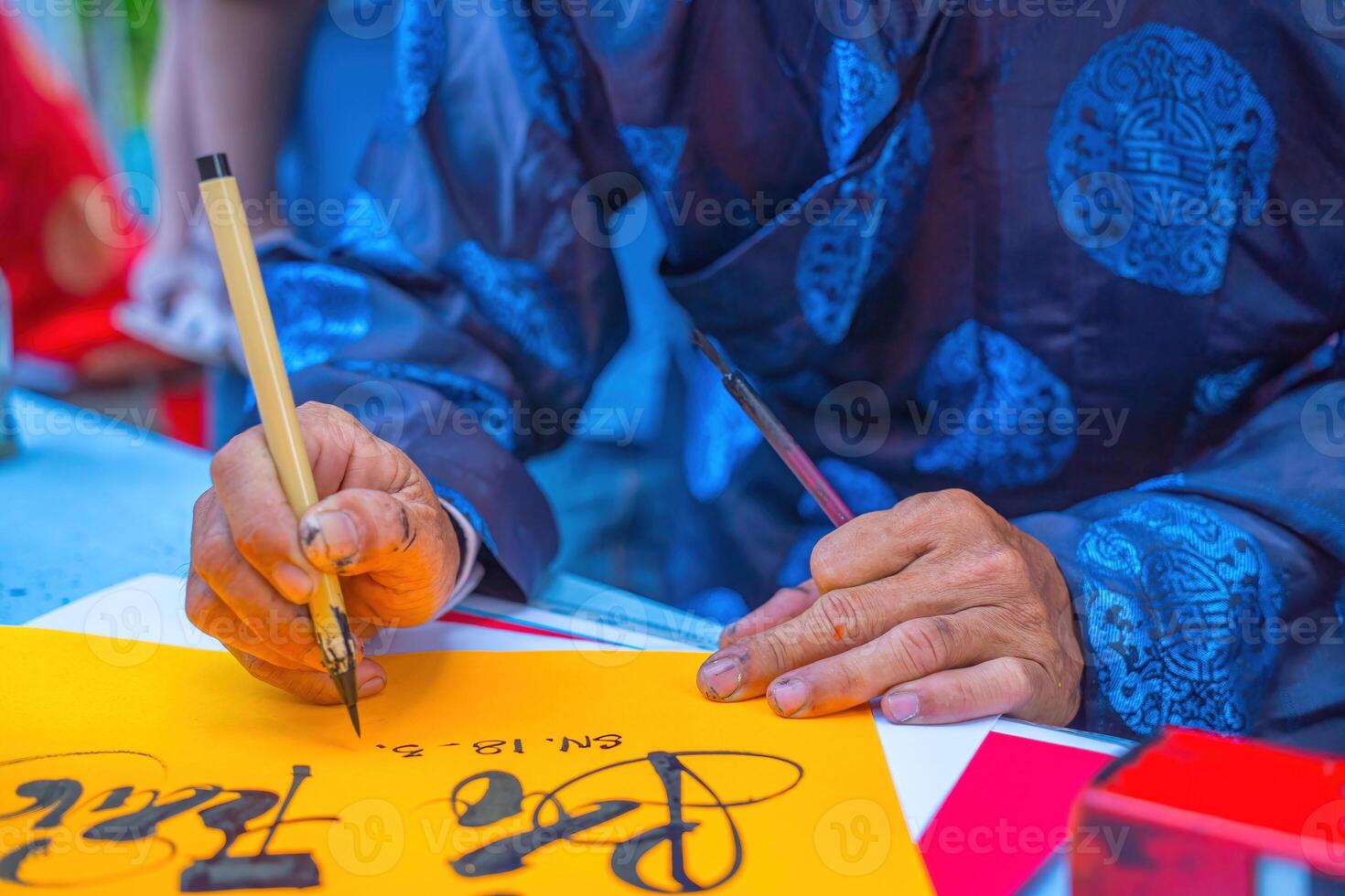 Vietnamese scholar writes calligraphy. Calligraphy festival is a popular tradition during Tet holiday. Writing couplets for Spring Festival, new year. photo