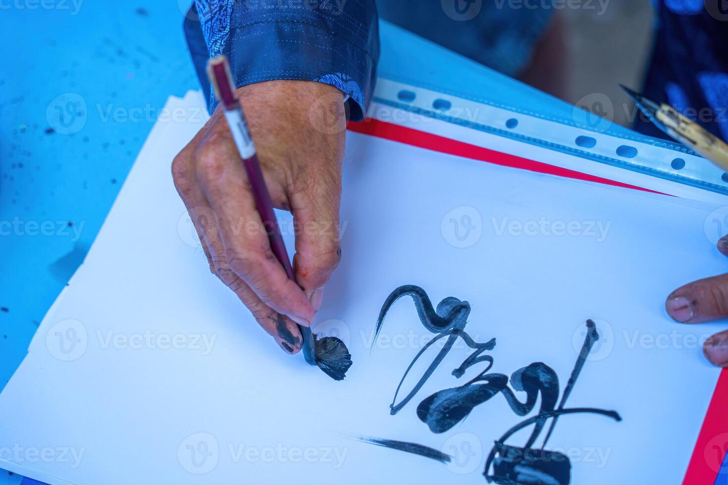 Vietnamese scholar writes calligraphy. Calligraphy festival is a popular tradition during Tet holiday. Writing couplets for Spring Festival, new year. photo