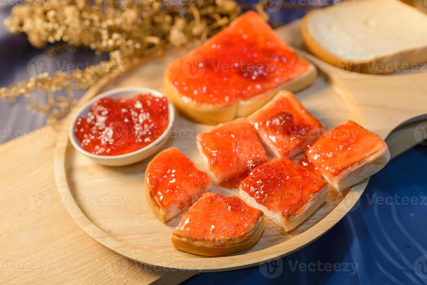 A wooden plate topped with bread and jelly photo